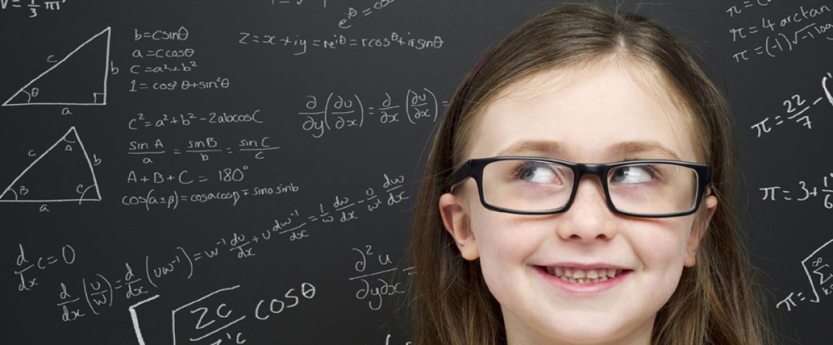 Smart young girl stood infront of a blackboard
