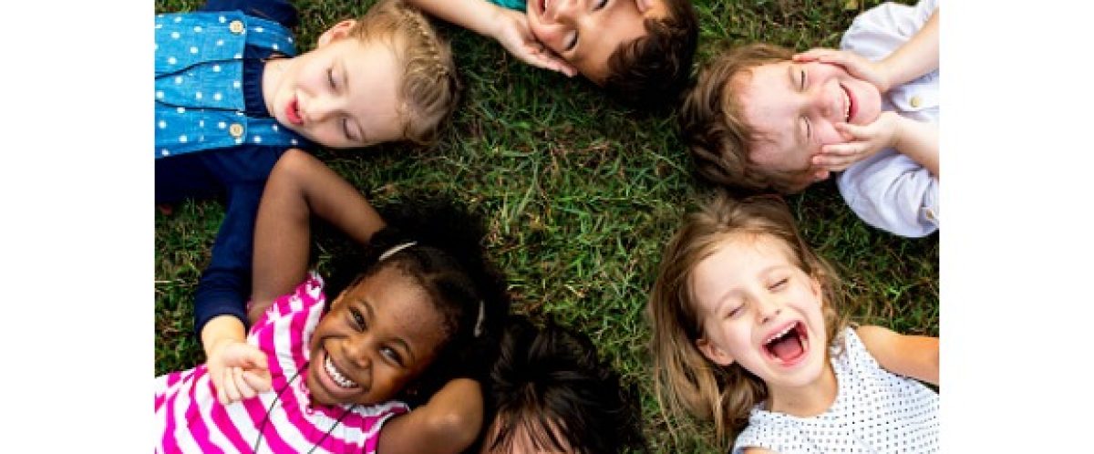 group-of-kindergarten-kids-lying-on-the-grass-at-park-and-relax-with-picture-id671260158